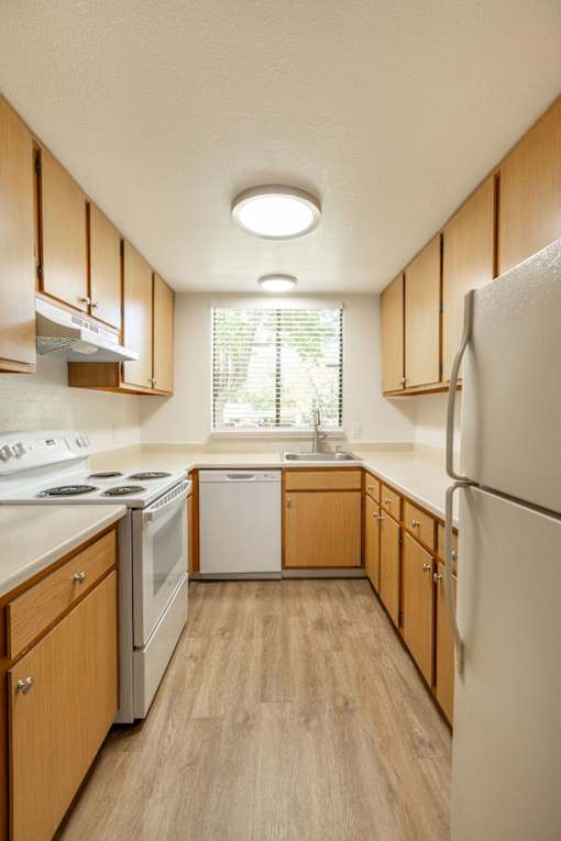 the preserve at ballantyne commons apartment kitchen with white appliances and wooden cabinets