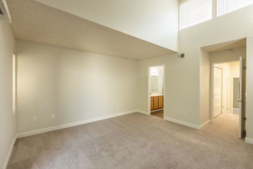 a living room with a carpeted floor and a door to a bathroom