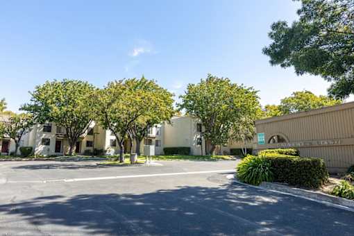 an empty parking lot in front of an apartment building