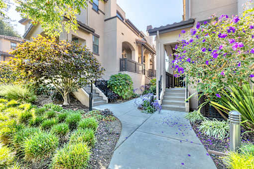 an apartment building with stairs and a sidewalk