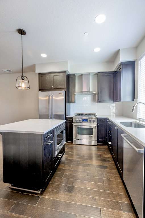 a large kitchen with stainless steel appliances and white countertops