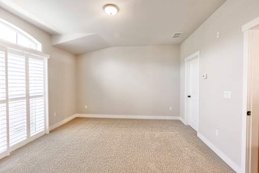 an empty living room with white walls and white door and window