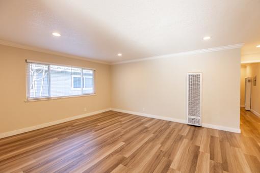 A room with wooden flooring and a window.