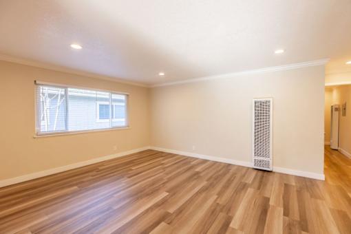 A room with wooden flooring and a window.