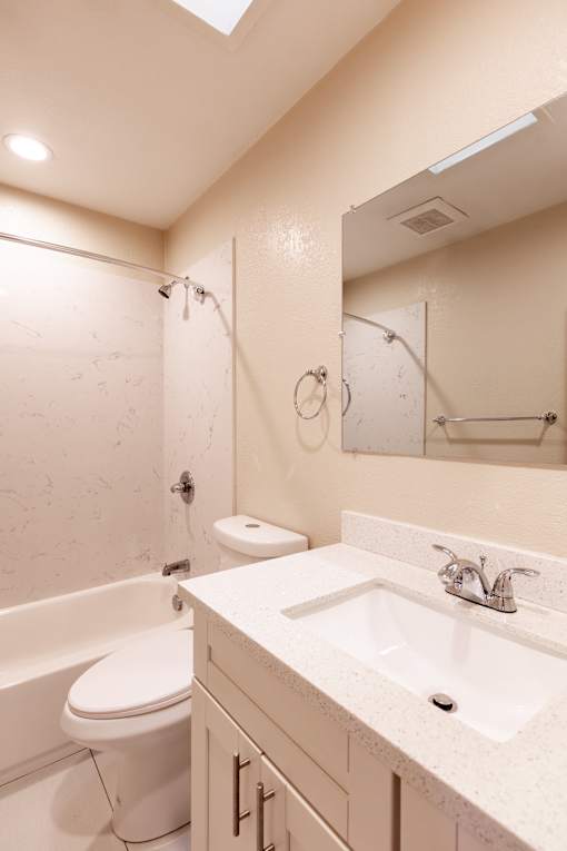 A white bathroom with a toilet, sink, and bathtub.