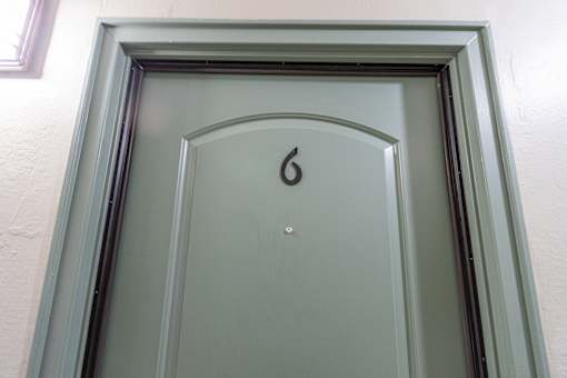 A green door with the number 6 on it.