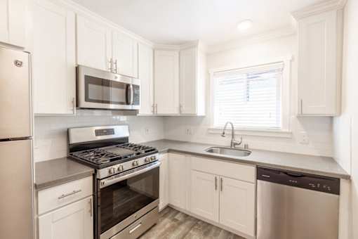 A kitchen with white cabinets and stainless steel appliances.