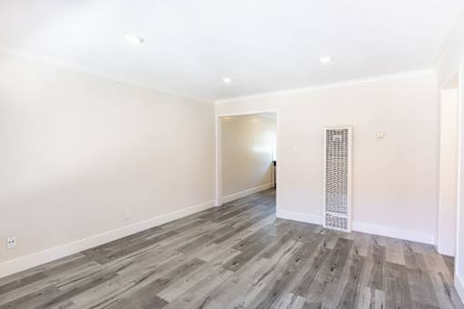 A room with a wooden floor and white walls.