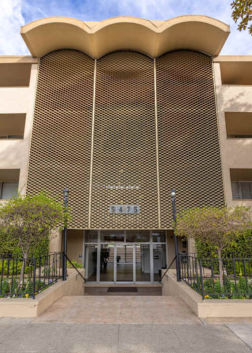 A building with a unique curved facade and a number 5475 on it.