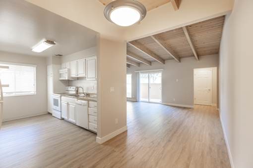A kitchen with white cabinets and a wooden floor.