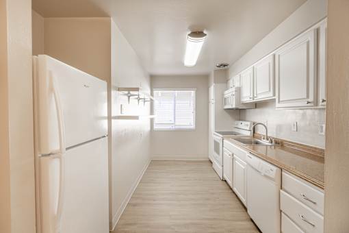 A kitchen with white appliances and cabinets.