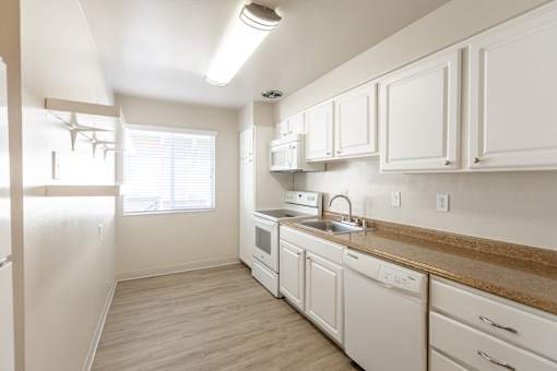 A kitchen with white cabinets and a wooden counter.