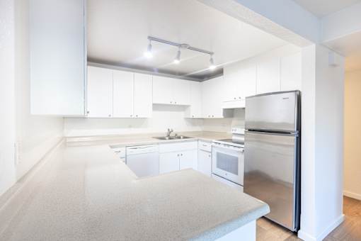 A kitchen with white cabinets and appliances.