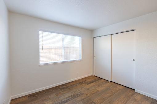 A room with a window and a sliding door.