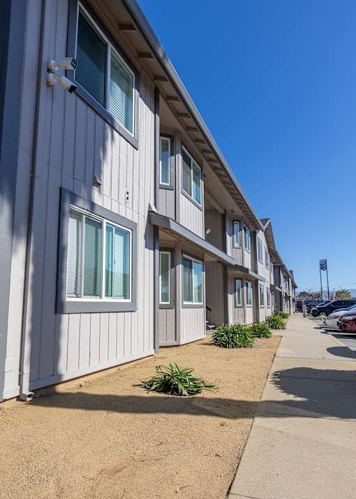 A row of houses with white siding and multiple windows.