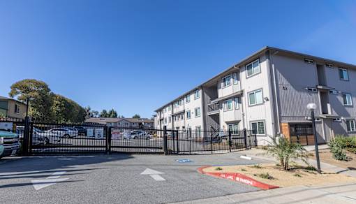 A gated entrance to a residential building with a clear blue sky above.