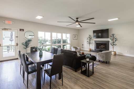 A living room with a fireplace and a dining table.