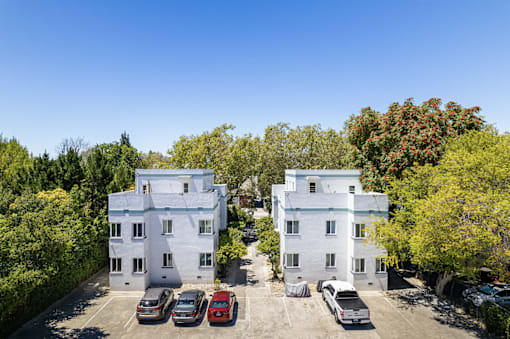 an aerial view of an apartment building with cars parked in front of it
