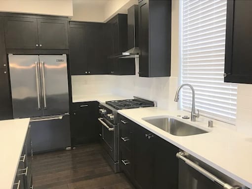 a black and white kitchen with a sink and refrigerator