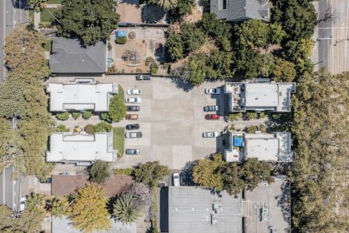 an aerial view of houses and trees in a parking lot