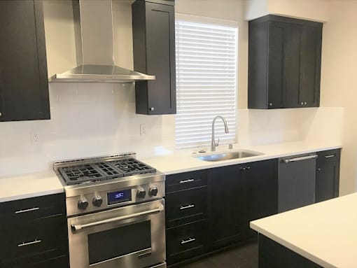 a kitchen with black and white counters and black appliances