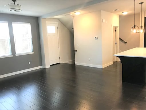 an empty living room with wood floors and a staircase