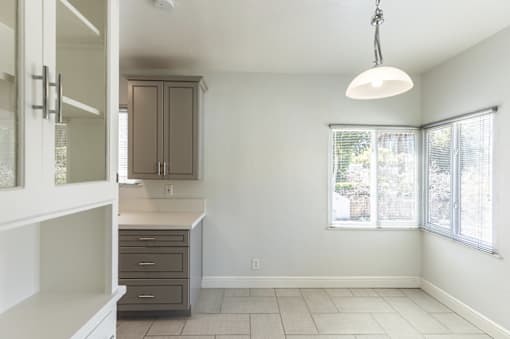 an empty kitchen with a window and a cabinet