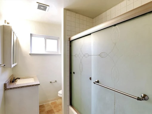 a bathroom with a toilet sink and shower