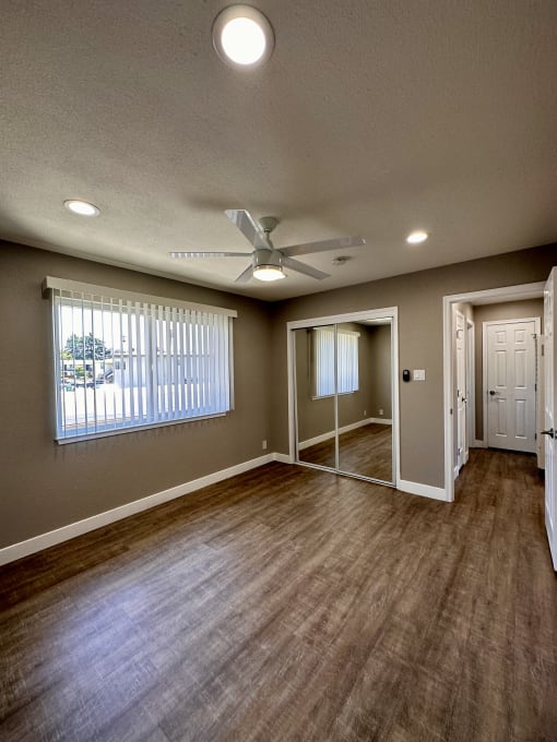 an empty living room with a ceiling fan