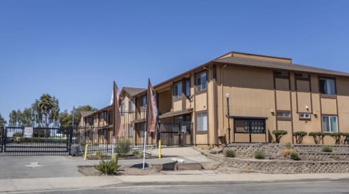 a building with a fence and flags in front of it