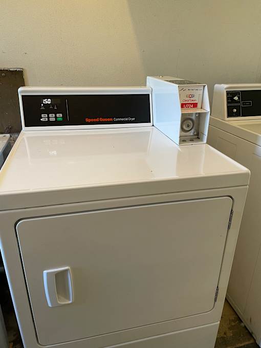 A white microwave oven with the door open and a control panel with buttons and a digital display.