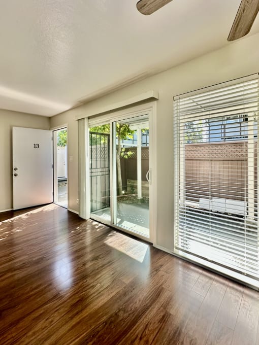 an empty living room with sliding glass doors to a patio