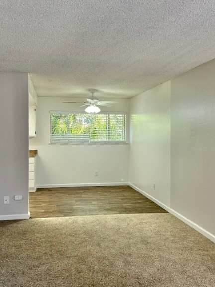 A room with a ceiling fan and a window with blinds.