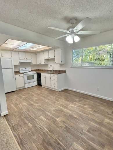 A kitchen with white cabinets and a ceiling fan.