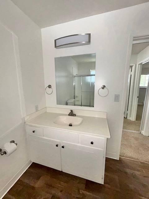 A white bathroom with a sink and mirror.