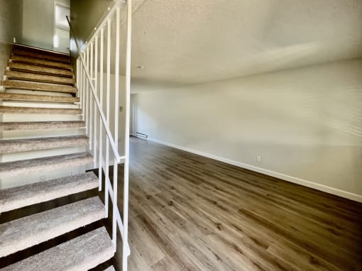 the upstairs of a house with stairs and wood flooring