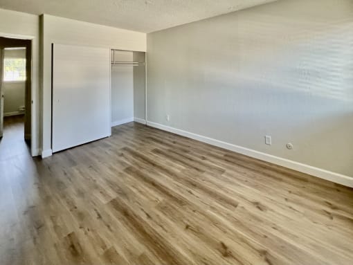the living room of an empty apartment with wood flooring
