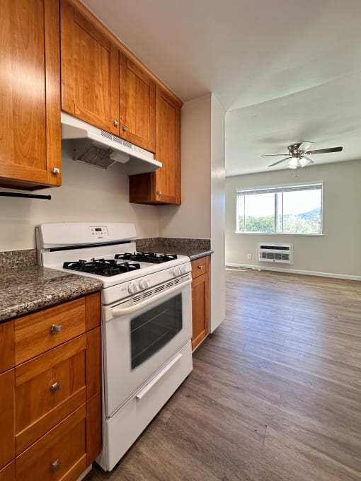 an empty kitchen with wooden cabinets and a white stove