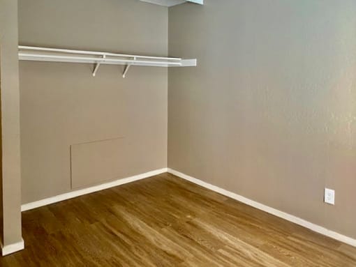 an empty room with wood floors and a white closet