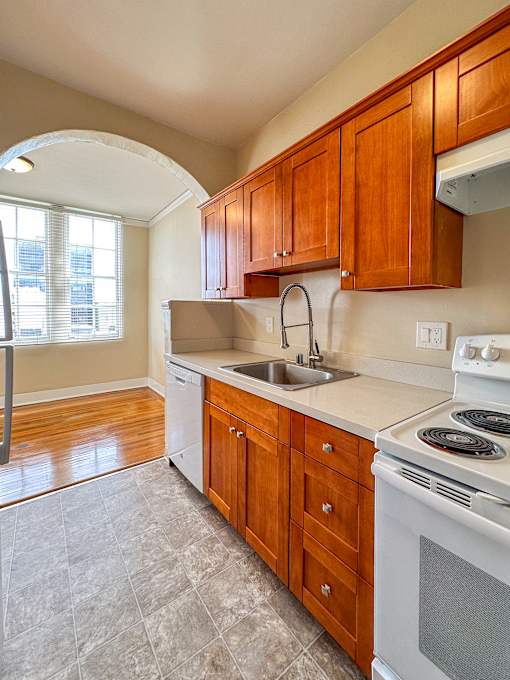 a kitchen with wooden cabinets and a stove and a sink