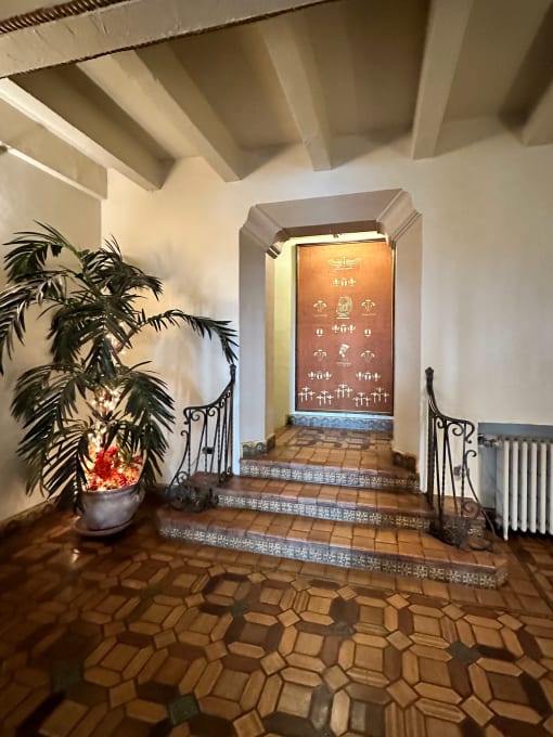 a hallway with a staircase and a potted plant    and a door