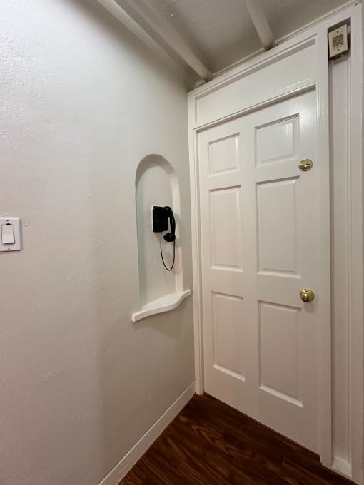 a white door with a phone hanging on the wall next to a closet