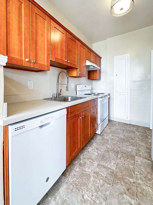 a kitchen with white appliances and wooden cabinets