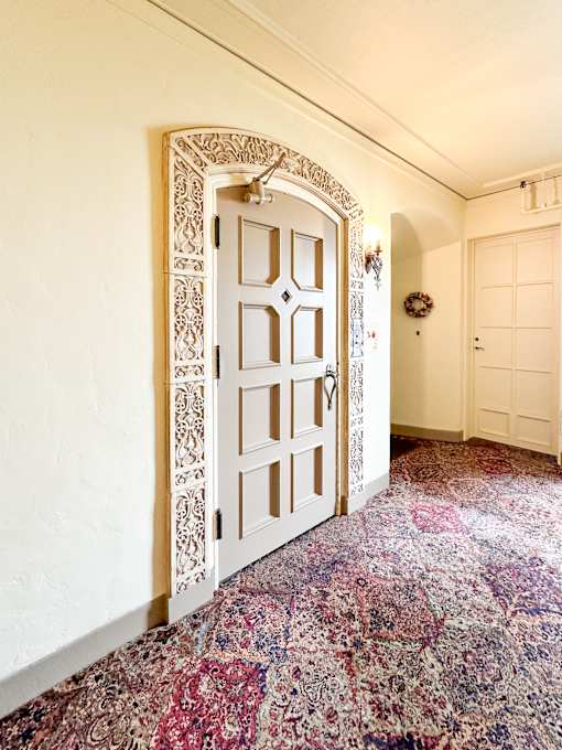 a door in a room with a carpet and a door frame