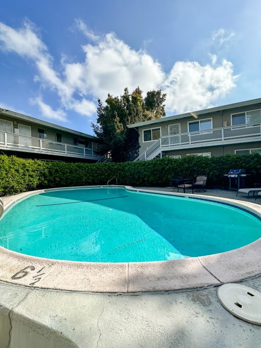 a swimming pool with an apartment building in the background