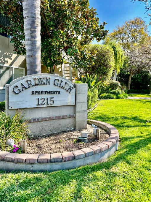 a sign apartments in front of a tree