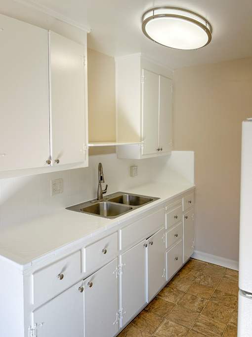 a kitchen with white cabinets and a sink