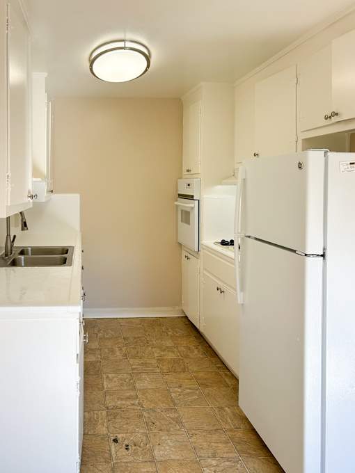 a kitchen with white appliances and white cabinets