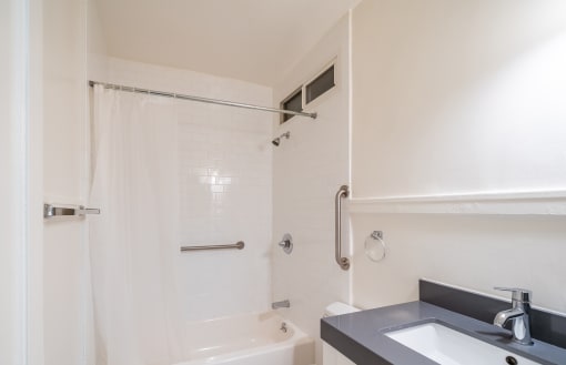 a bathroom with a sink and a shower and a bath tub
