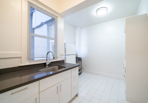 an empty kitchen with a sink and a window
